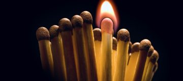 cerilla encendida entre otras apagadas para encender en emprender