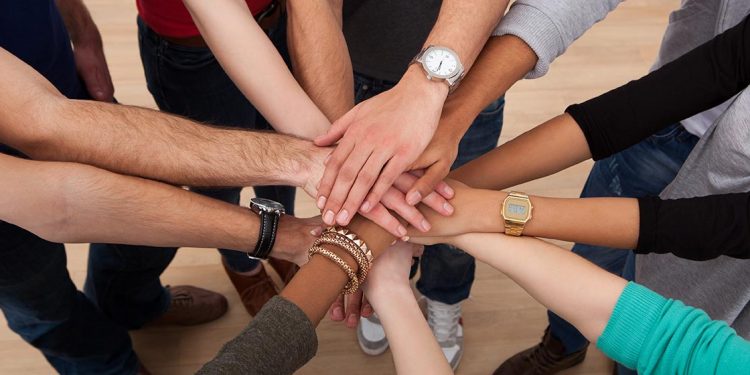 Conjunto de manos unidas para ejemplificar el trabajo en equipo