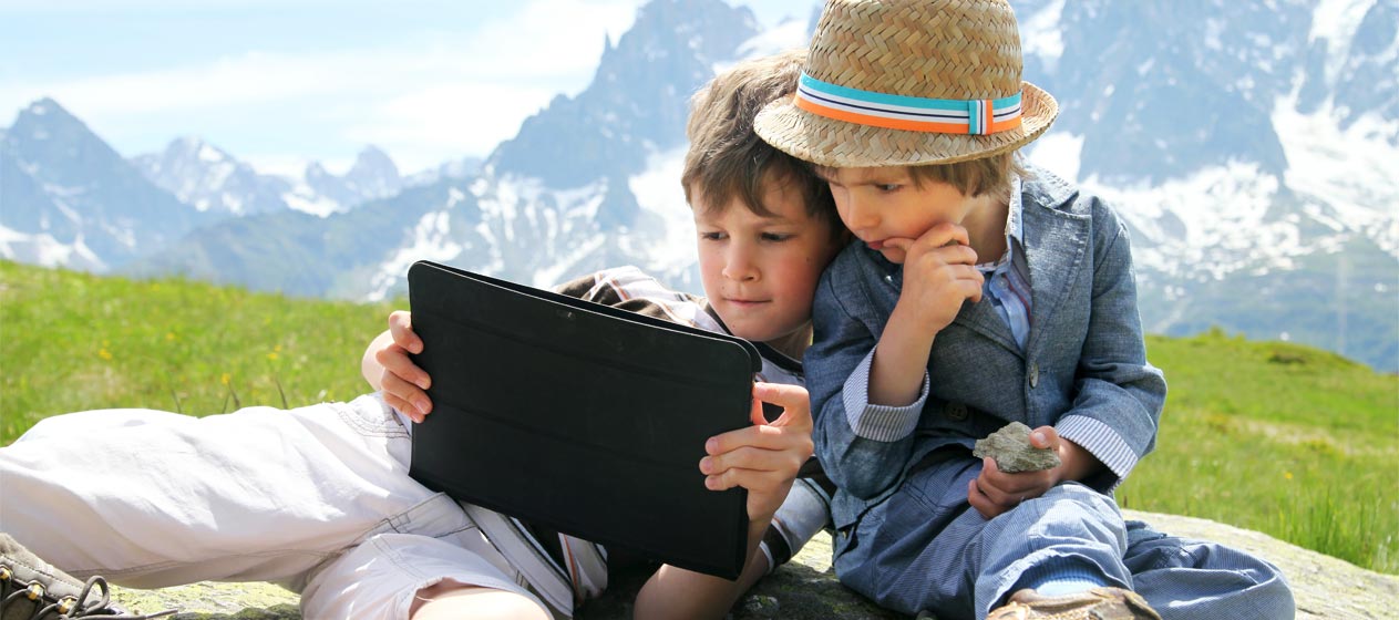dos niños con un ipad en una montaña representando el u-learning