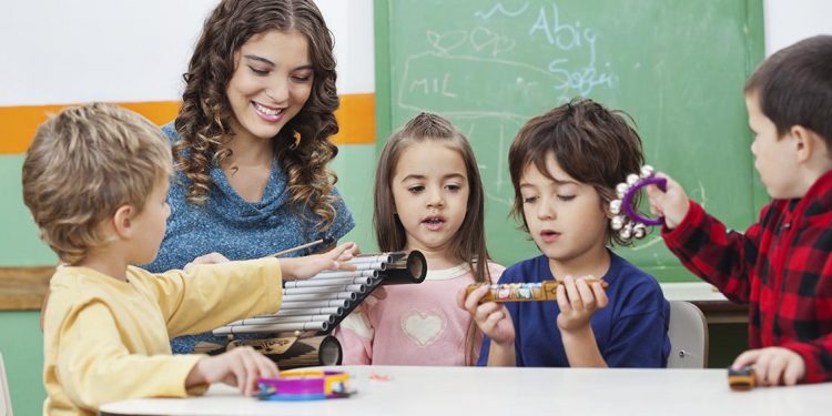 Niños sosteniendo instrumentos musicales en un aula para ilustrar el valor educativo de la música