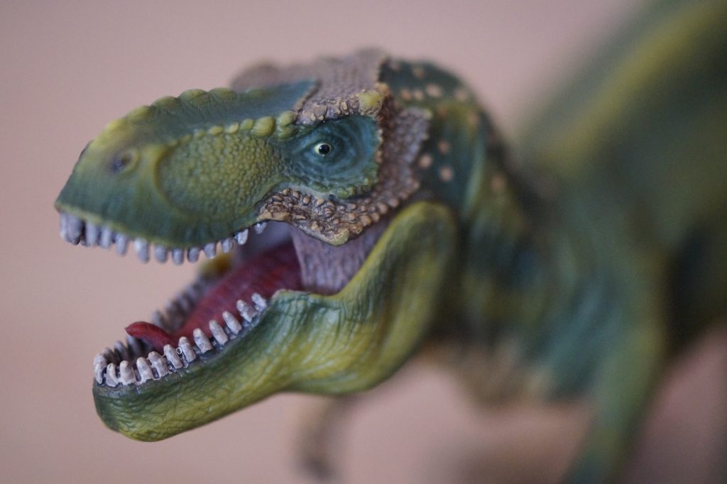 Figura de Tyrannosaurus Rex entre recursos educativos de dinosaurios