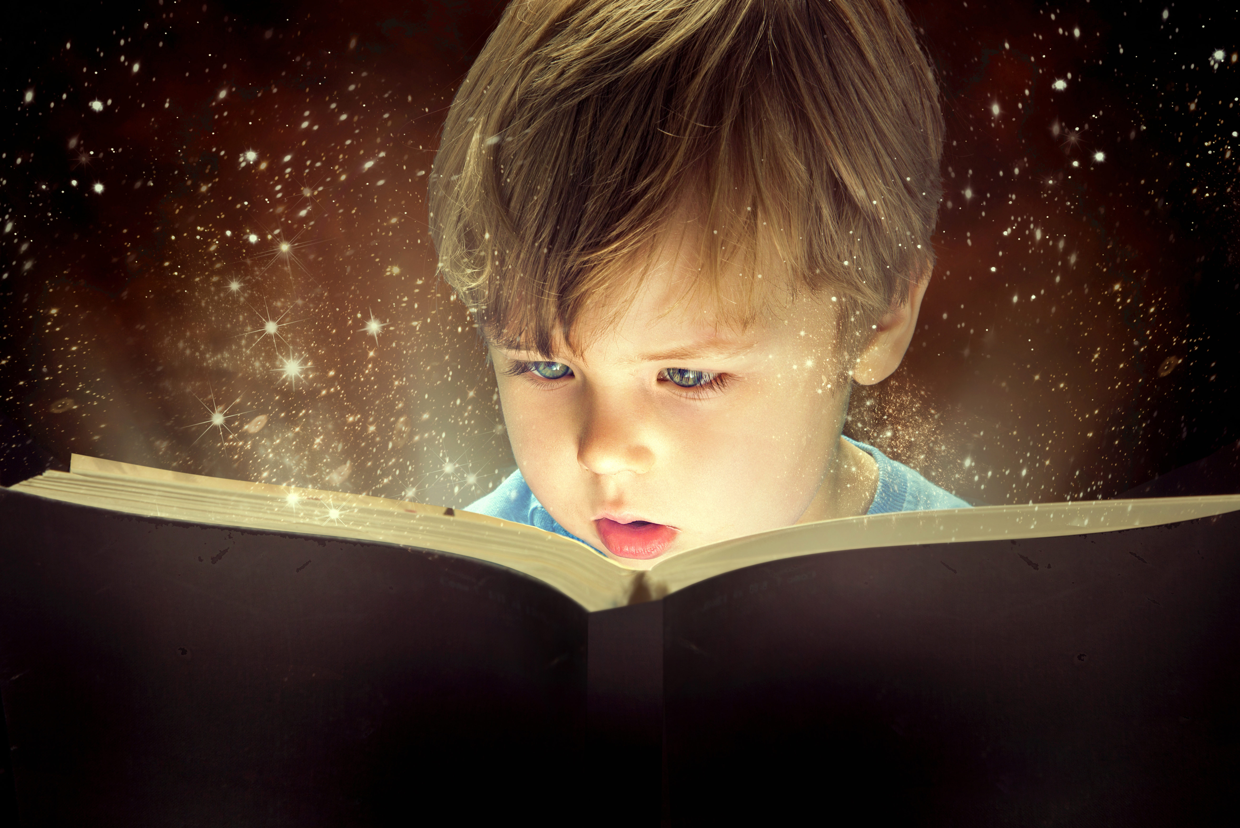 nen llegint amb espurnes sortint del llibre per a contes