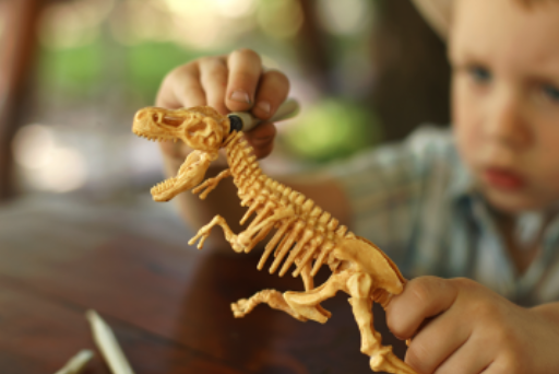 nen amb dinosaure per marxem de vacances