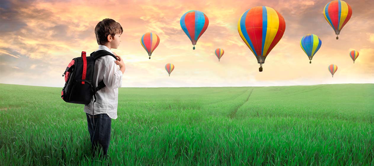 Niño con un mochila observando globos aerostáticos en libros para viajar