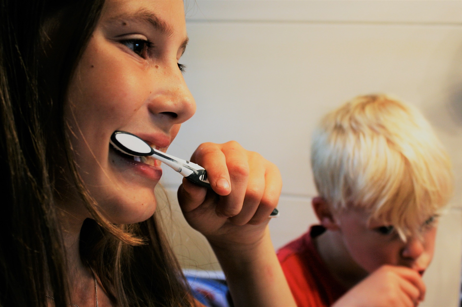 Dos nens raspallant-se els dents per il·lustrar els bons hàbits