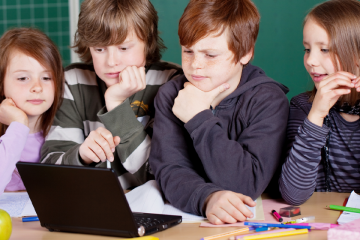 niños en clase mirando un ordenador pensando para microlearning