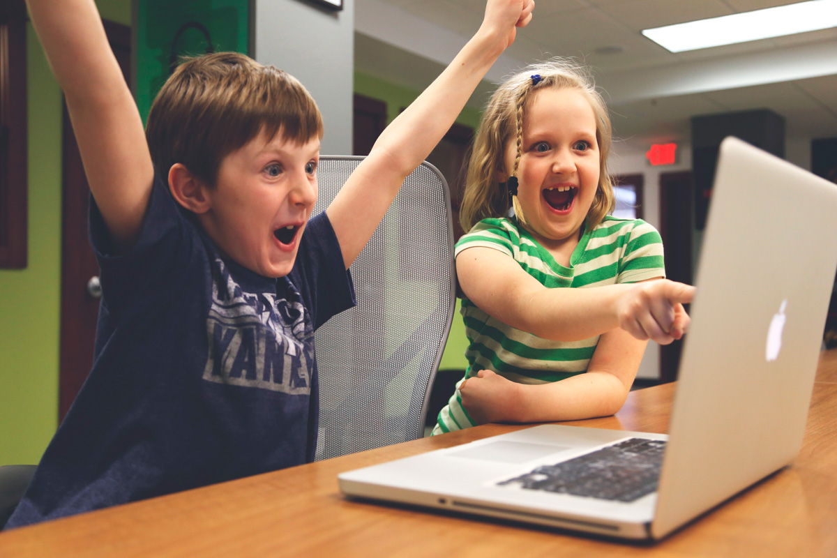Dos nens amb un portàtil per il·lustrar l'educació a distància