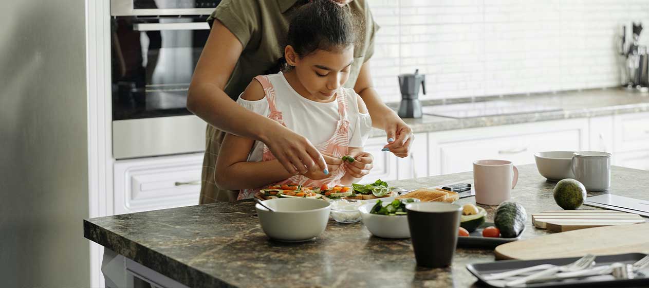 Niña y madre en la cocina para una gastronomía sostenible