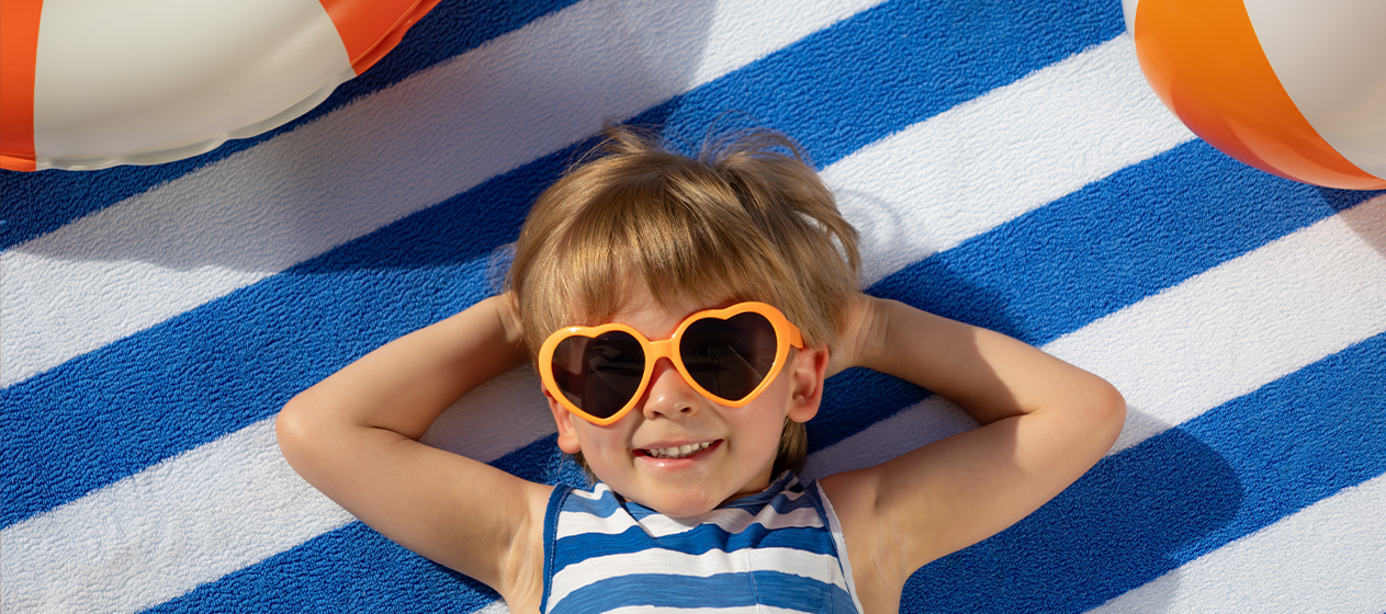 niño tumbado con gafas de sol divertidas para feliz verano