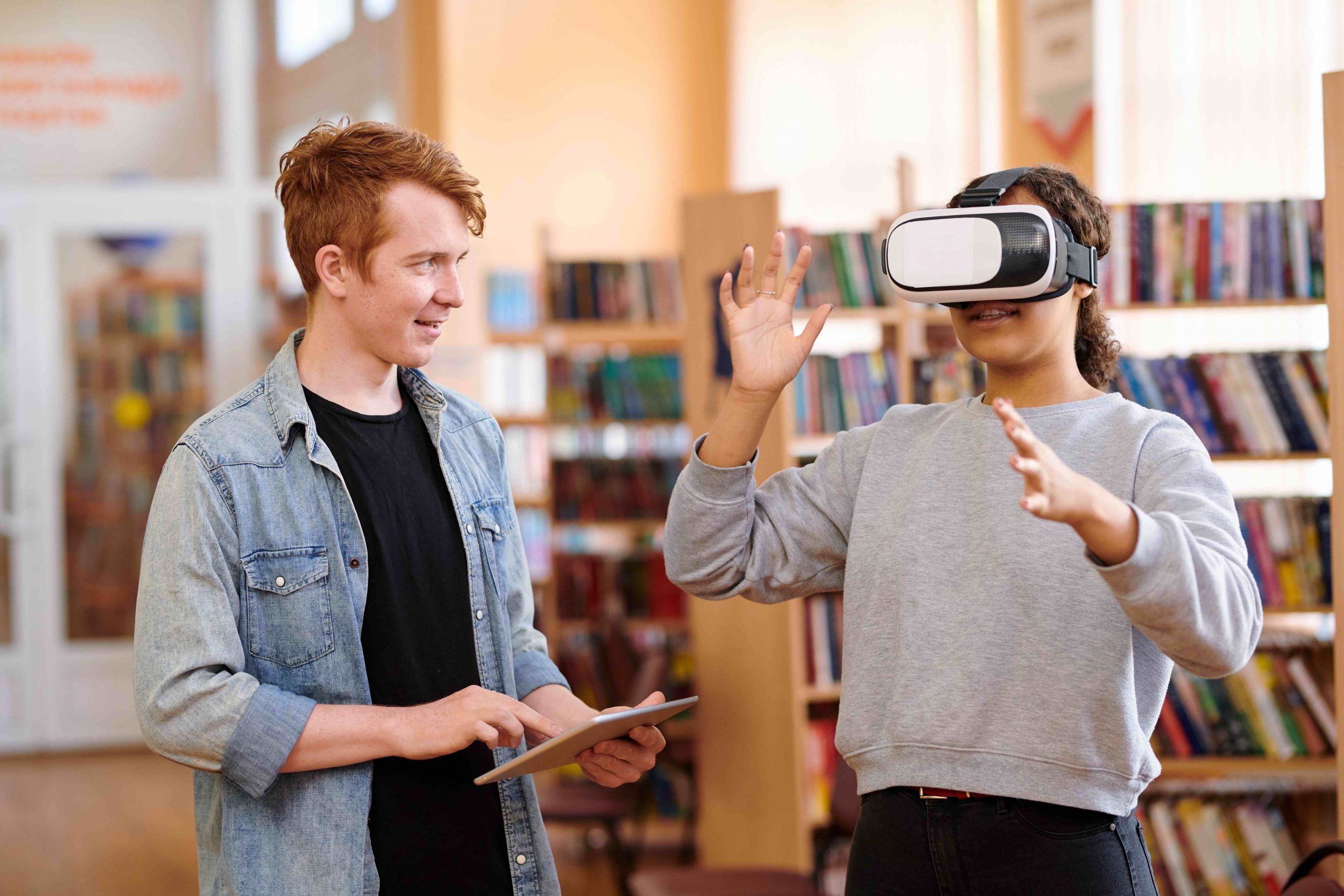 Estudiants a una biblioteca amb ulleres de Realitat Virtual per il·lustrar els recursos digitals
