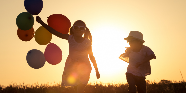 niña con globos y niño a contraluz en puesta de sol para artículos para disfrutar con calma