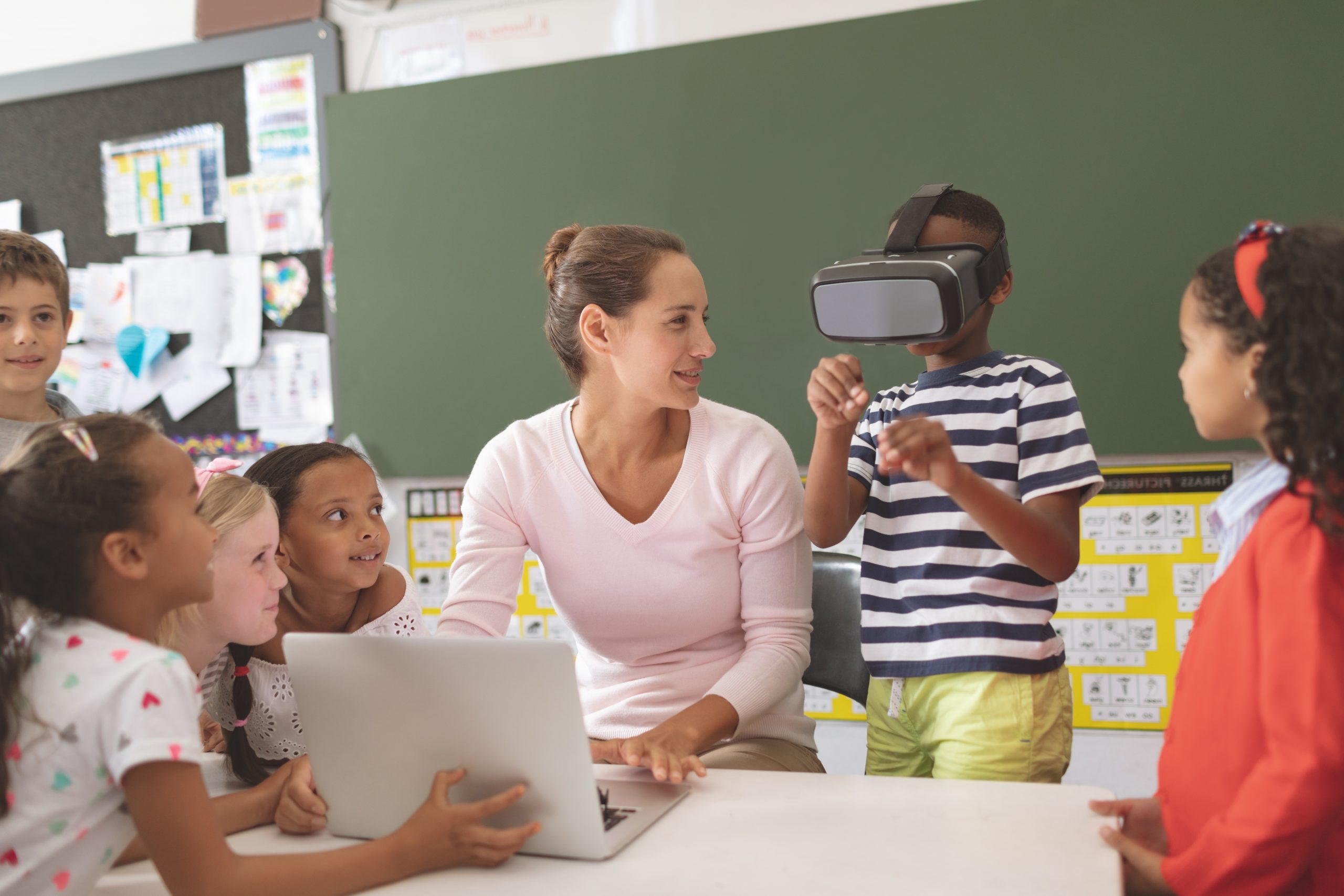 grup de nens a classe un d'ells provant la realitat virtual per a metavers i l'educació
