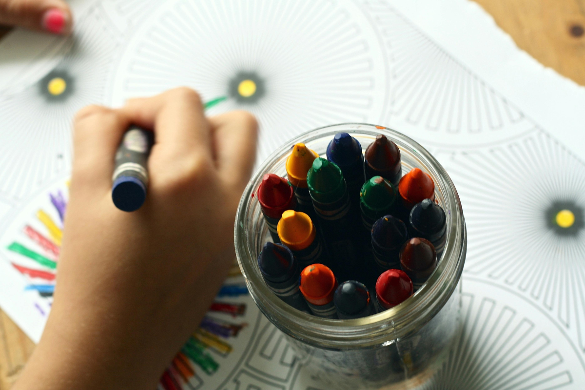 Niño coloreando con crayones en el aula