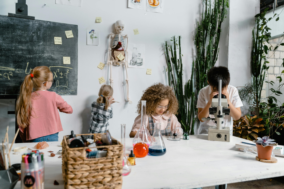 Niños usando un microscopio en clase de ciencias