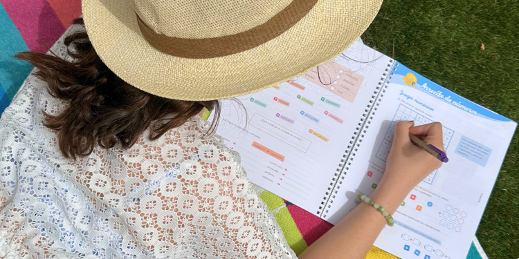 Niña haciendo actividades del cuaderno de vacaciones ¡Splash! de Vicens Vives